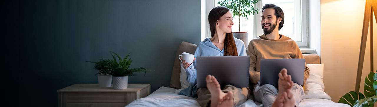 A couple in bed with their laptops